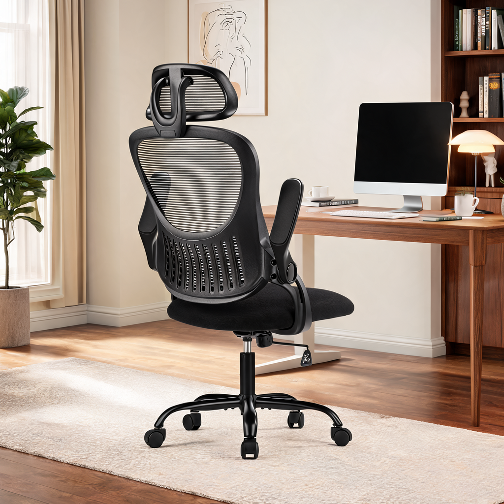 Black high back chair on a pale rug facing a desk with a monitor and full bookshelves
