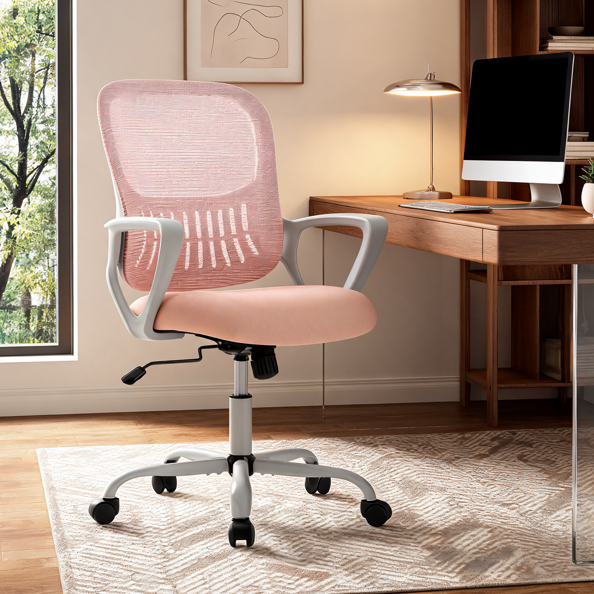 Pink seat office chair with a white five star base at a desk beside a window with trees outside