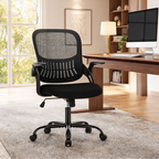 Black mesh office chair on a shaggy rug in front of a window and a wooden desk with a monitor