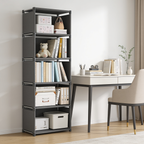 Dark gray five tier shelf unit standing beside a desk in a bright bedroom corner