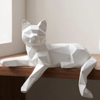 White faceted cat figurine lying along a wood shelf edge with one paw hanging